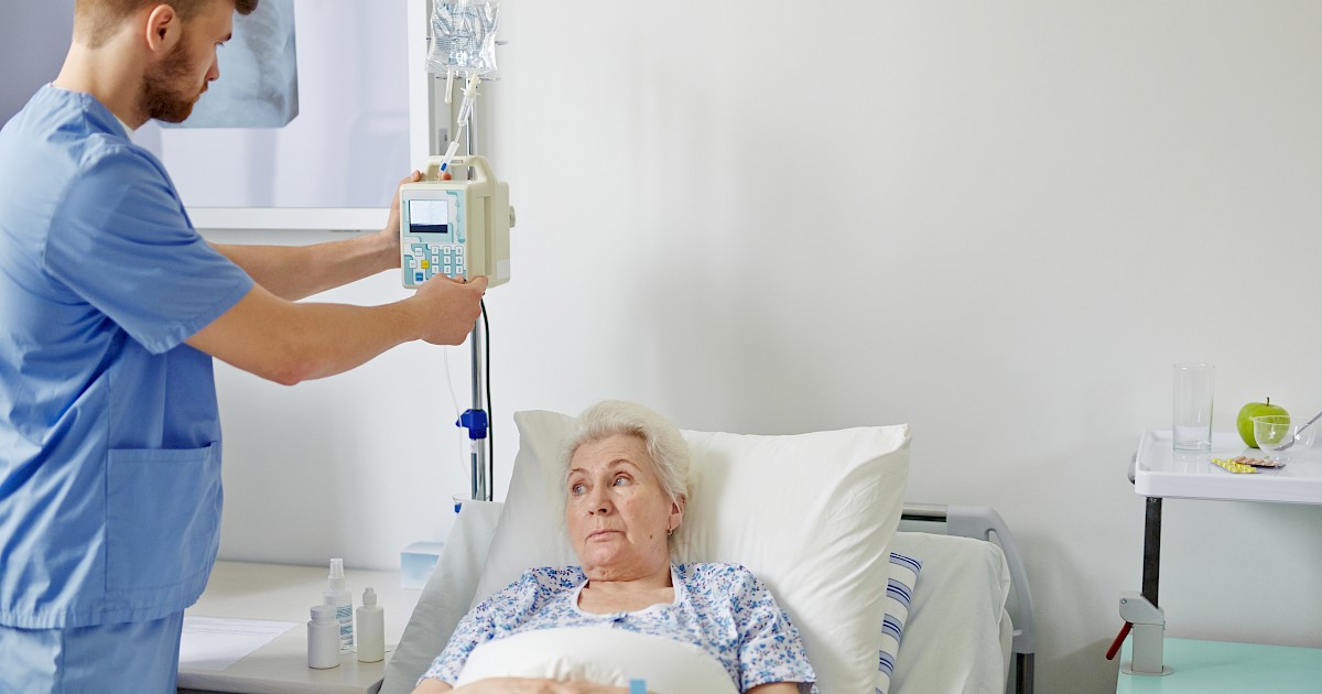 male nurse fixing infusion pump for patient