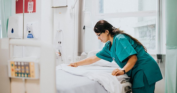 Nurse making hospital bed