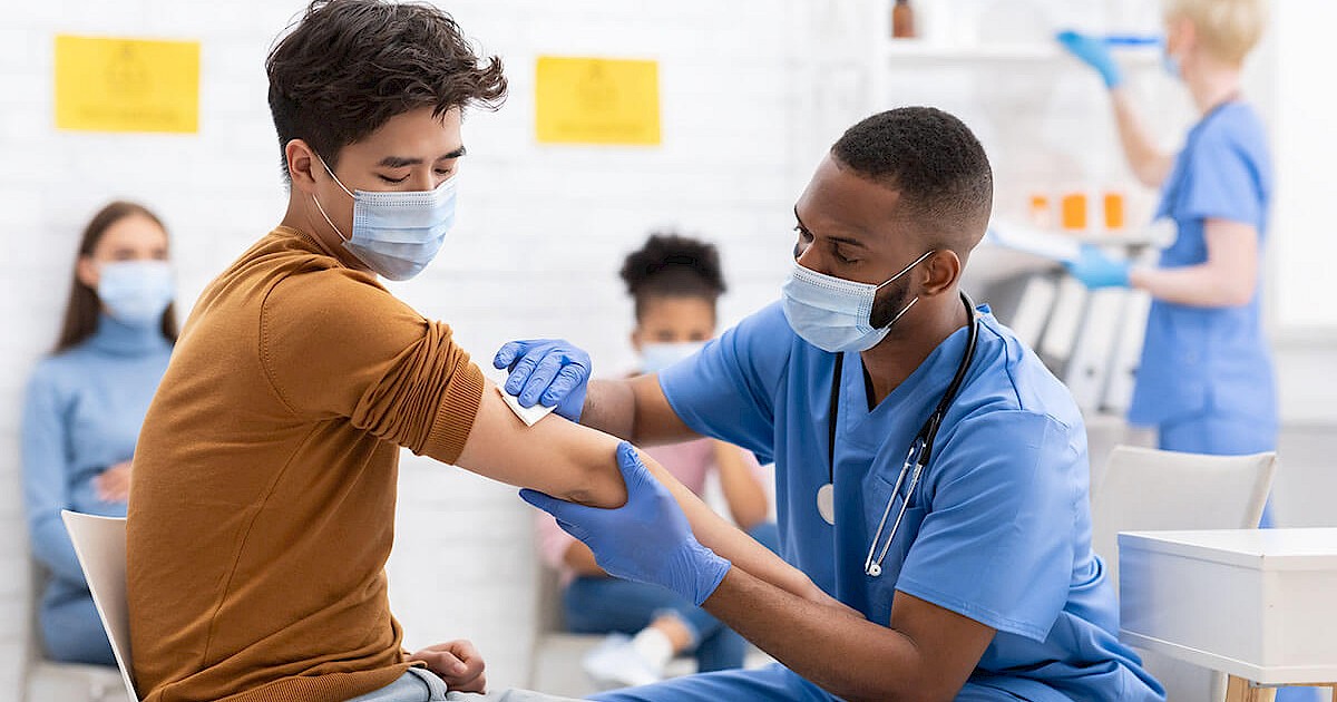 Nurse giving young man COVID-19 vaccine